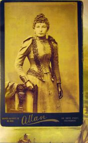 sepia photograph of a lady in a tight fitting suit .