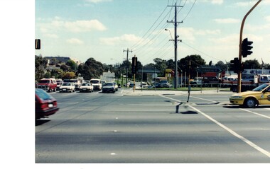 Coloured photograph of the intersection. Springvale Road in the foreground. Canterbury Road heading toward Forest Hill Chase Shopping Centre.