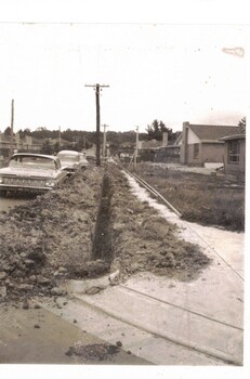 Black & white photograph of a trench dug in preparation for laying gas pipes in Aubrey Street Mitcham.