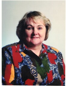 Jessie McCallum . Wearing multi coloured blouse. Short blond hair.