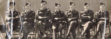 Black and white photograph of 7 airmen seated in uniform.