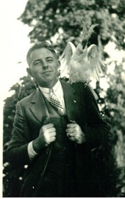 Black & white photograph of a man with a cockatoo on his left shoulder.
