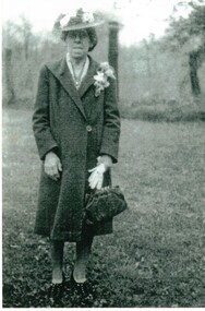 Black and white photograph of Mary Jack. Holding a handbag and wearing a corsage.