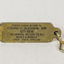 Small oblong badge with key ring attached. 