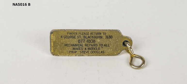 Small oblong badge with key ring attached. 