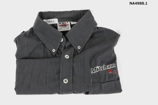  Grey short sleeved man's shirt "Mitcham" and "R.S.L" embroidered on left hand side above left hand pocket. 