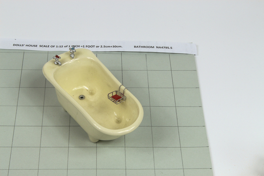 miniature bath with two taps, drain hole and soap drainer