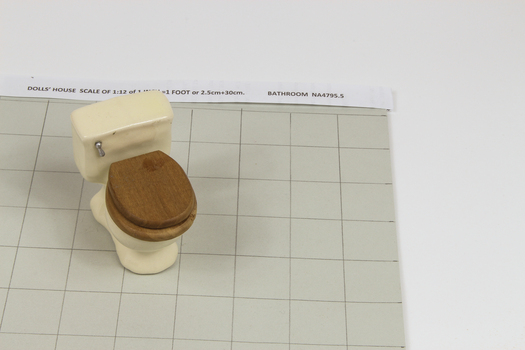 Miniature toilet with brown wooden seat and lid, silver flush handle
