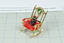 Gold-coloured, metal rocking chair with re seat cushion and black plastic cat