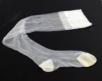 One winter white nylon stocking with reinforced heel and toe - very sheer, probably 10 denier & feather shaped leg.