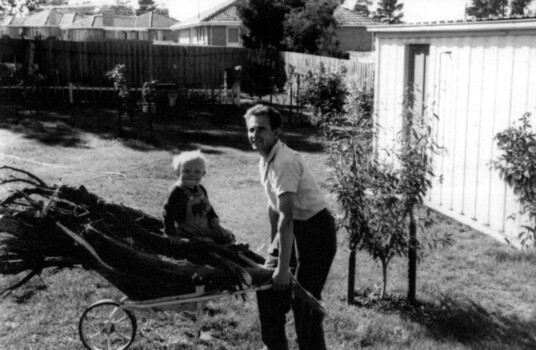 Roy and Nick Rogalski with wheelbarrow in backyard