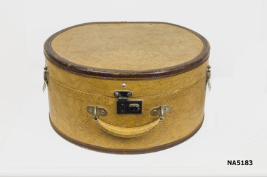 Tan leatherette hat box with brown leather binding.