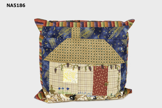 Square cushion with patchwork design of Schwerkolt Cottage.