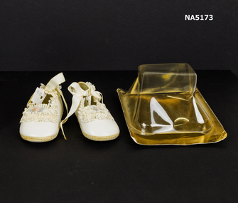 Cream baby shoes  with plastic box.
