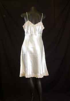 Petticoat has coffee coloured lace around the hem and yoke. It has rouleau style shoestring straps.