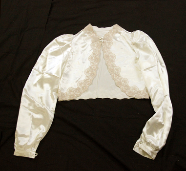 Bedjacket is short with long sleeves and a front fastening with four self-covered buttons. Coffee coloured 