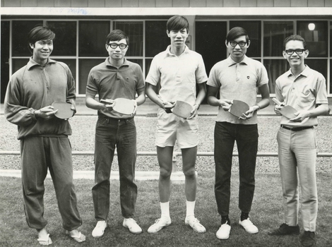 Five male residents of International House, each smiling and holding a table tennis paddle. 