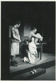 Two male actors and one female on stage in costume for the play.