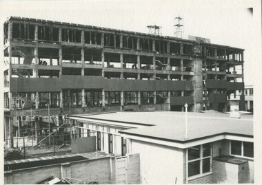Scaffolding around a partially built building c. 1956 