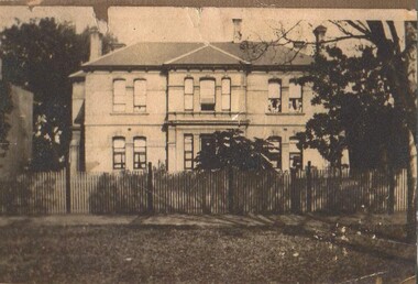A black and white photo of a house with regency architectural influence. 