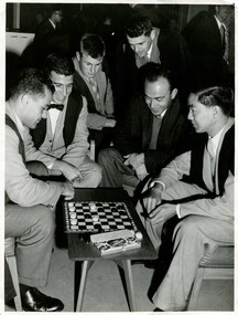 Six well dressed men around a checkers table. 