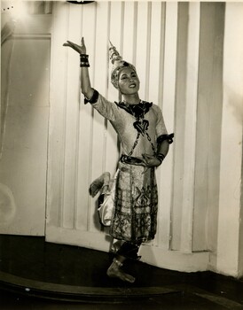 Young male student in Thai sarong holding a traditional dance pose. 