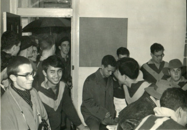 Room of men in football uniforms, smiling and chatting