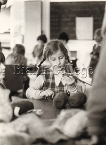 Photograph - Student sitting in a classroom and knitting, c. 1980s, c. 1980s