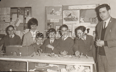 Photograph, Principal Moshe Meretz with teacher and students in a classroom, c. 1960s