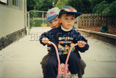 Photograph (Item) - ELC students riding a tricycle, c. 1990s, c. 1990s