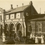 Three men and six nurses stand in front of a double storey hospital