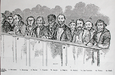 Eleven men sit in a dock awaiting trial