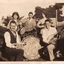 Five musicians are photographed with their instruments