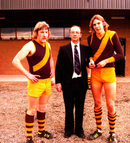 Two footballers and a man in a suit