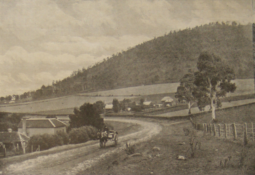 Wagon on a road in front of a mountain. 
