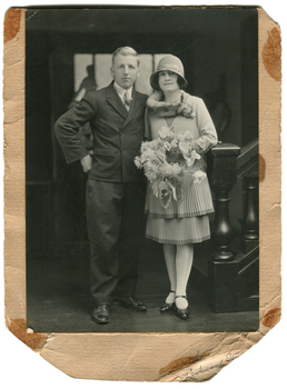 A man and a woman stand in front of a staircase
