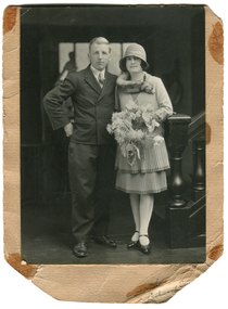 A man and a woman stand in front of a staircase