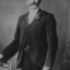 A man stands with a flower in his lapel