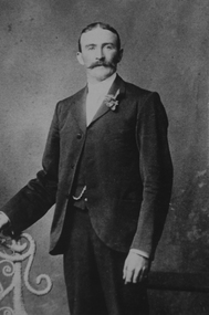 A man stands with a flower in his lapel