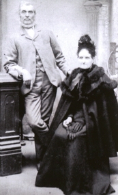 A standing man and a seated woman