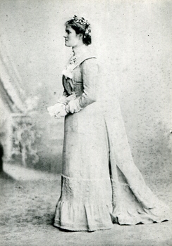 A bride stands hlding flowers
