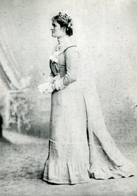 A bride stands hlding flowers
