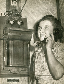 Image - Black and White, Woman on a party-line wall telephone, c1950