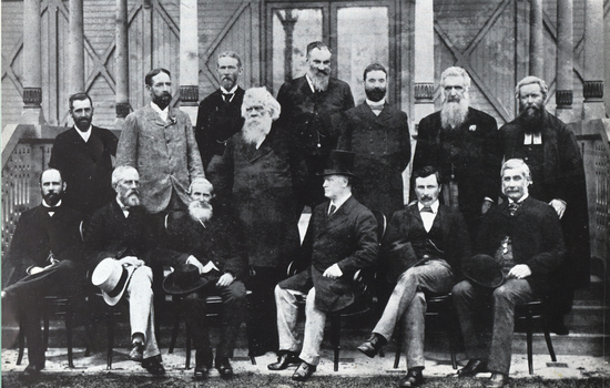 Fourteen men stand and sit