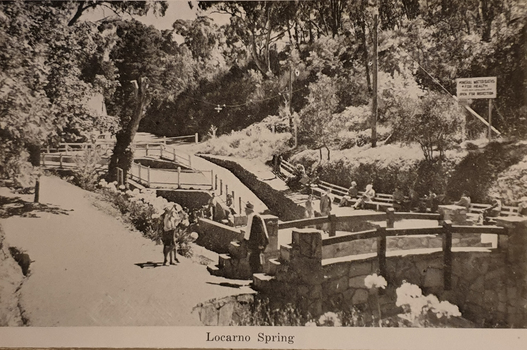 A stone bridge is situated in the foreground, with Locarno Spring in the background