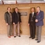 Four men surround a plaque