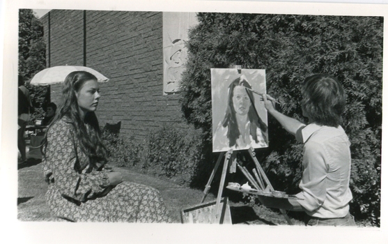 a man paints the portrait of a woman
