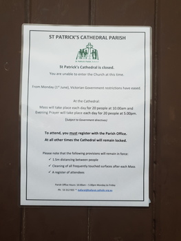 Sculptural face on St Patrick's Cathedral, Ballarat Covid 19 notice