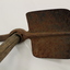 Small metal shovel with a pick spike on the other end, used for digging trenches and latrines. It also has a small wooden handle.