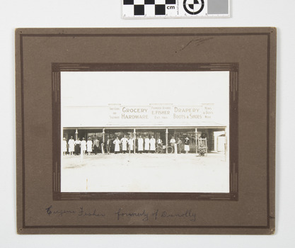 This image depicts 17 staff including Mr and Mrs E Fisher(formerly of Dunnolly) on footpath in front of store